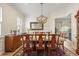 Elegant dining room featuring a chandelier, decorative wallpaper, and an adjacent kitchen view at 2408 Bending Oak Loop, Mount Pleasant, SC 29466
