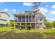 Rear exterior view showcasing a light blue two-story home with a screened porch and lush green lawn at 2408 Bending Oak Loop, Mount Pleasant, SC 29466
