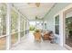 Inviting screened porch with wicker furniture, tile flooring, and serene views of the surrounding landscape at 2408 Bending Oak Loop, Mount Pleasant, SC 29466