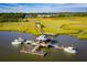 Aerial view of community marina featuring docks and boat slips in a coastal waterway surrounded by marshland and homes at 2815 Colonel Harrison Dr, Johns Island, SC 29455