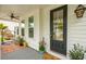 This inviting front porch includes seating, plants and a welcome mat, creating a warm entry at 2815 Colonel Harrison Dr, Johns Island, SC 29455