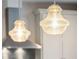 Close-up of the kitchen island's pendant lighting with decorative glass shades and brushed metal hardware at 2815 Colonel Harrison Dr, Johns Island, SC 29455