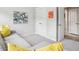 A gray sectional sofa with yellow throw pillows faces a white wall with colorful artwork at 2815 Colonel Harrison Dr, Johns Island, SC 29455