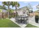Beautiful backyard with a dining set, seating, palm trees, and green grass at 2866 Sugarberry Ln, Johns Island, SC 29455