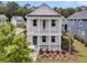 Two-story white home featuring a double-decker porch and professional landscaping at 2866 Sugarberry Ln, Johns Island, SC 29455