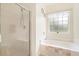 Bathroom featuring a glass-enclosed shower, bathtub, and window with natural light at 308 Pickering Ln, Charleston, SC 29414