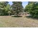 Well-maintained front yard featuring a lush lawn, mature trees, manicured shrubbery, and a charming brick home at 356 Hobcaw Dr, Mount Pleasant, SC 29464