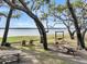A waterfront park area with picnic tables, swings, and benches under large trees at 356 Hobcaw Dr, Mount Pleasant, SC 29464