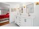 Bright bathroom with a double vanity and an adjacent bedroom with a red bedspread at 39 N Adgers Wharf, Charleston, SC 29401