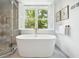 Bright bathroom featuring a freestanding tub and a glass shower with a view at 39 N Adgers Wharf, Charleston, SC 29401