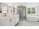 Modern bathroom with a double vanity, glass shower and a freestanding tub at 39 N Adgers Wharf, Charleston, SC 29401