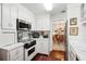 Well-lit kitchen with wooden floors, white cabinetry, and view into the dining room at 39 N Adgers Wharf, Charleston, SC 29401