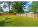 Large backyard with a wooden fence, green grass, and a fire pit, perfect for outdoor activities and gatherings at 411 Black Horse Rd, Moncks Corner, SC 29461