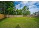 Spacious backyard with a wooden fence, a fire pit, and lush green grass, offering ample room for recreation at 411 Black Horse Rd, Moncks Corner, SC 29461