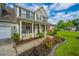 Charming home featuring a welcoming covered front porch with beautiful landscaping at 411 Black Horse Rd, Moncks Corner, SC 29461