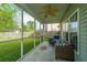 Comfortable screened porch with wicker seating, ceiling fan, and view of the spacious, fenced backyard at 411 Black Horse Rd, Moncks Corner, SC 29461