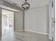 A dining room featuring a modern light fixture, gray walls, and updated gray flooring leading to the sunroom at 414 Courtland Dr, Summerville, SC 29486