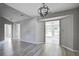 A dining room featuring gray walls, a modern light fixture, updated gray flooring, and access to the sunroom at 414 Courtland Dr, Summerville, SC 29486