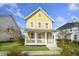 Charming two-story yellow home with a welcoming front porch and well-maintained lawn on a sunny day at 4906 W Liberty Park Cir, North Charleston, SC 29405