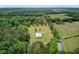 This aerial shot highlights a property nestled among lush trees, and featuring a large shop building at 4911 Chisolm Rd, Johns Island, SC 29455