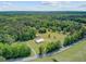 An expansive aerial captures a large property with a metal building, surrounded by lush trees and scenic landscape at 4911 Chisolm Rd, Johns Island, SC 29455