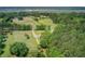 Aerial view showcasing a country property with marsh views, featuring a large building and surrounding greenery at 4911 Chisolm Rd, Johns Island, SC 29455