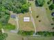 This aerial view showcases a property with multiple buildings, lush greenery, and a long driveway at 4911 Chisolm Rd, Johns Island, SC 29455