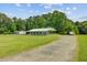 Exterior view of home with a long covered porch and surrounding trees at 4911 Chisolm Rd, Johns Island, SC 29455