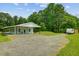 Exterior view of home with a long covered porch, gravel driveway and surrounding yard at 4911 Chisolm Rd, Johns Island, SC 29455