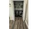 Laundry closet featuring two black washer and dryers on gray plank flooring and lots of shelving at 4911 Chisolm Rd, Johns Island, SC 29455