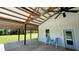 Exterior shot of spacious porch with ceiling fan, seating, and painted corrugated siding at 4911 Chisolm Rd, Johns Island, SC 29455