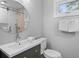 Bathroom featuring a round mirror over a sink, a toilet, and a shower with glass doors at 507 Cobby Creek Ln, Seabrook Island, SC 29455