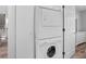 Laundry area with stacked washer and dryer, dresser, and view towards stairs at 507 Cobby Creek Ln, Seabrook Island, SC 29455