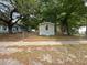 Street view of a single-wide mobile home featuring mature trees and a chain link fence at 5626 Shelton St, North Charleston, SC 29406