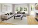 Elegant living room with a fireplace, comfortable seating, and scenic windows at 575 Red Monarch Way, Moncks Corner, SC 29461