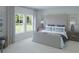 Serene main bedroom with large windows, neutral colors, and comfortable furnishings at 575 Red Monarch Way, Moncks Corner, SC 29461