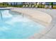 Zero entry pool area with beach entry, ample seating, and lush landscaping along the perimeter at 575 Red Monarch Way, Moncks Corner, SC 29461
