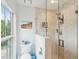 Modern bathroom with a glass-enclosed shower, white fixtures, and a window with a view of the outdoors at 62 Gadsden St # A, Charleston, SC 29401