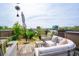 Relaxing rooftop patio featuring cozy outdoor seating, umbrella, plants, and city views, perfect for leisure and entertainment at 62 Gadsden St # A, Charleston, SC 29401
