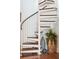 Spiral staircase with wood treads complemented by vases and pots, adding a touch of elegance to the home's interior at 62 Gadsden St # A, Charleston, SC 29401