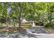 A long driveway leads to a brick home surrounded by large trees and lush landscaping at 679 Edmonds Dr, Charleston, SC 29412