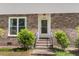 Close up of the front brick entrance with a white door and greenery at 679 Edmonds Dr, Charleston, SC 29412