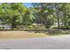 Charming home featuring a brick facade, well-manicured lawn, and mature trees at 679 Edmonds Dr, Charleston, SC 29412