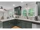 Bright kitchen featuring a peninsula counter, dark green cabinets, white backsplash and stainless steel appliances at 679 Edmonds Dr, Charleston, SC 29412