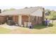 Exterior view of back of home with lawn, patio and water collection equipment at 7712 Corley Dr, North Charleston, SC 29418