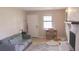 Living room featuring brick fireplace, gray sofa, front door and natural light through a window at 7712 Corley Dr, North Charleston, SC 29418