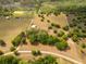 Sprawling acreage featuring a home, pond, and surrounding trees with white fencing at 7875 Berry Manor Ln, Edisto Island, SC 29438