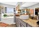 Bright bathroom features a soaking tub beneath a window with natural light at 7875 Berry Manor Ln, Edisto Island, SC 29438