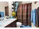 Well-lit bathroom with a vanity, toilet, and a shower featuring a patterned curtain at 7875 Berry Manor Ln, Edisto Island, SC 29438