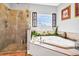 This bathroom features a corner soaking tub, a glass shower, and decorative window at 7875 Berry Manor Ln, Edisto Island, SC 29438